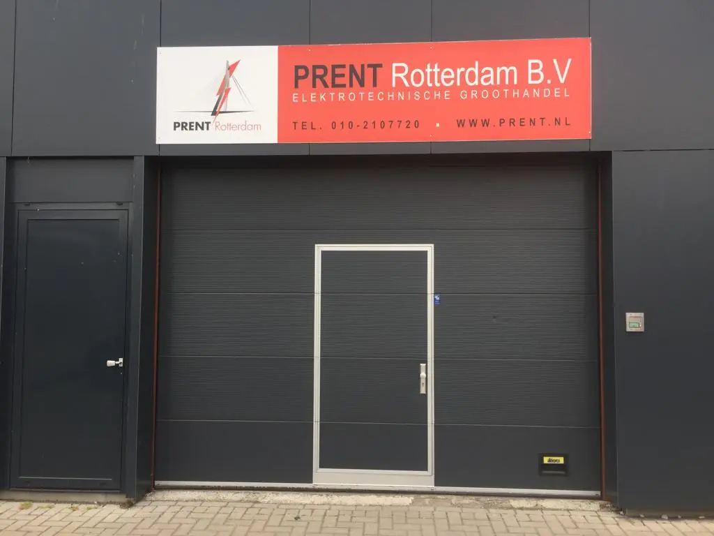 Het pand van Prent Rotterdam: donkergrijze gevel met rood-wit Prent-bord boven de roldeur